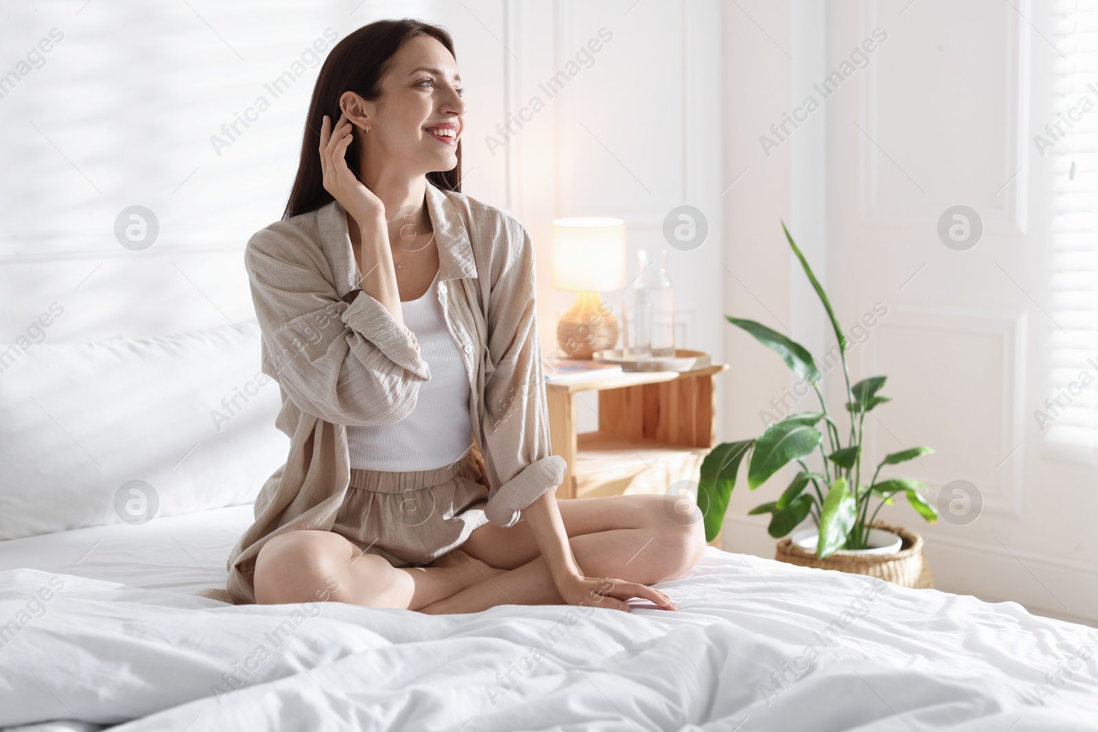 Photo of Woman on bed with soft mattress at home. Space for text