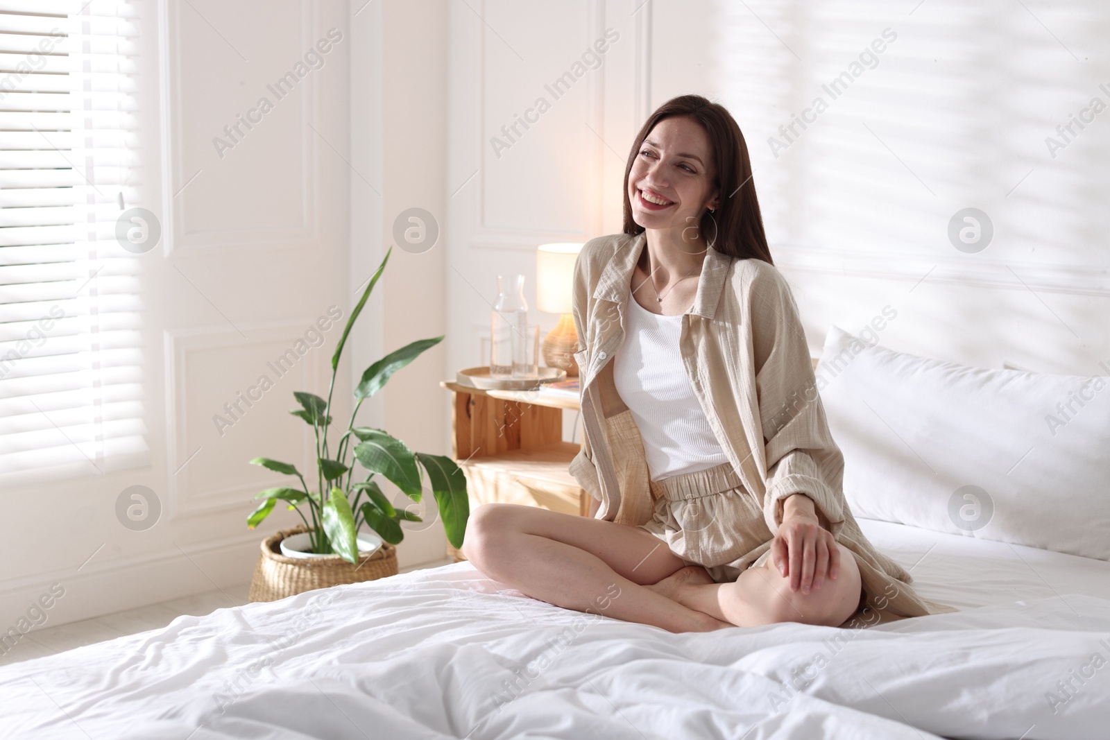 Woman on bed with soft mattress at home. Space for text Photo of Woman on bed with soft mattress at home. Space for text