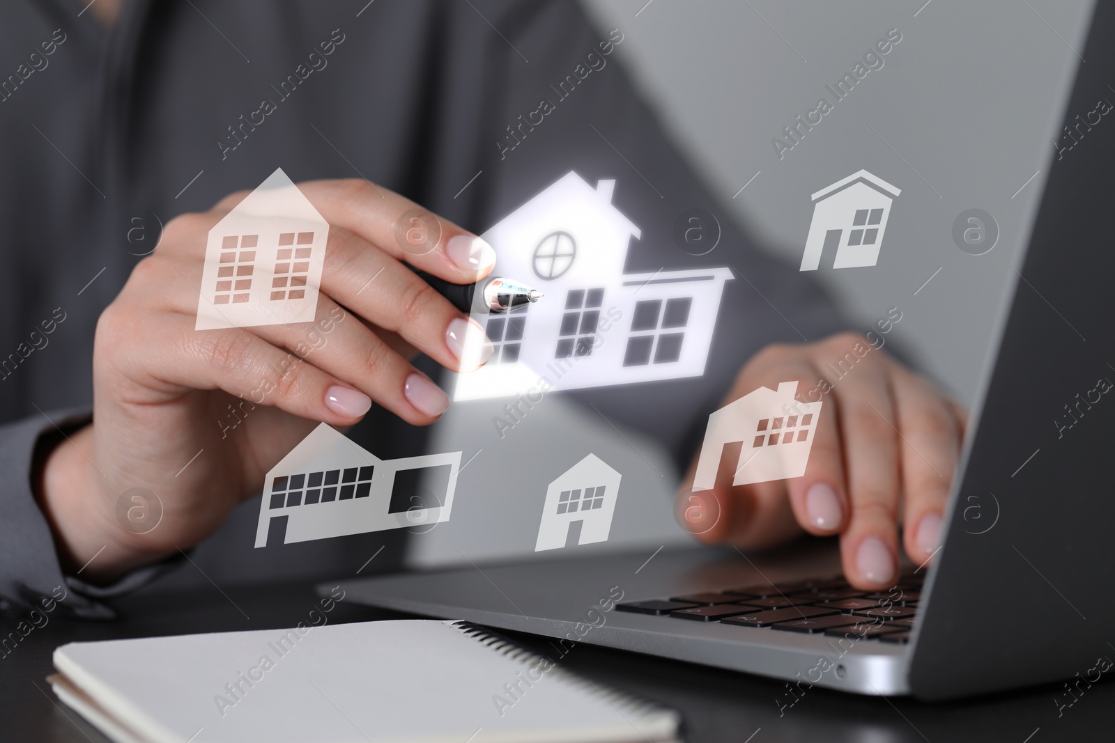 Real estate agent touching house icon on virtual screen above laptop at table, closeup. Search for housing Image of Real estate agent touching house icon on virtual screen above laptop at table, closeup. Search for housing