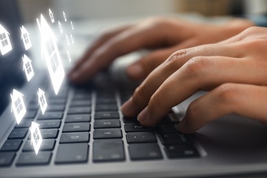 Image of Real estate agent looking for housing via laptop at table, closeup. Illustrations of buildings over device