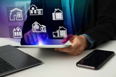 Image of Real estate agent looking for housing via tablet at white table, closeup. Illustrations of different buildings over device