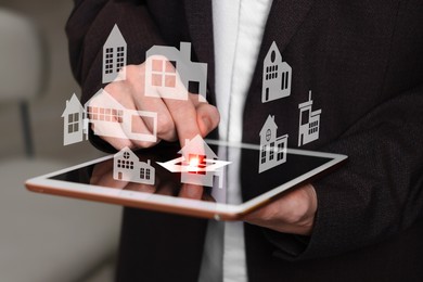 Image of Real estate agent looking for housing via tablet indoors, closeup. Illustrations of different buildings over device