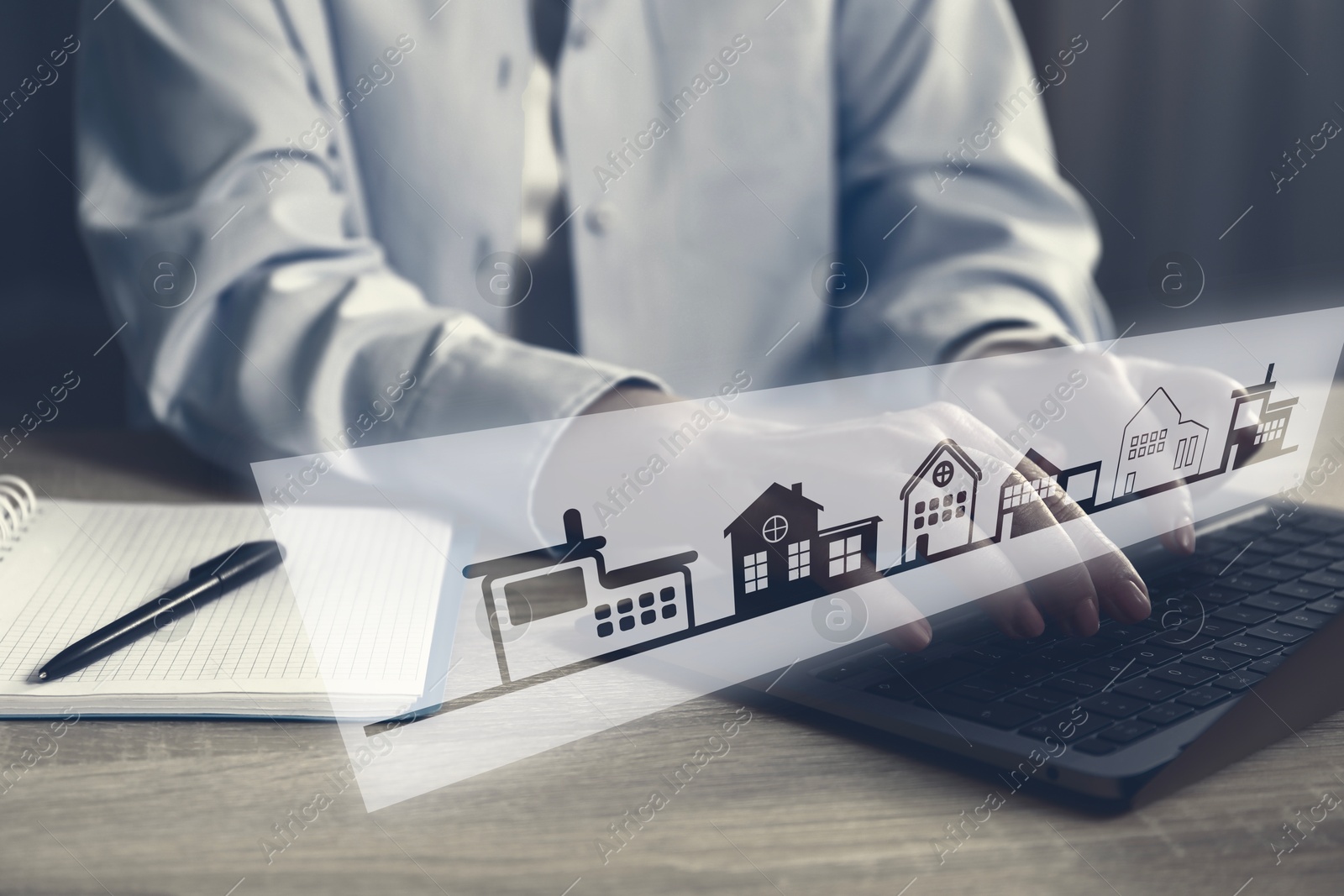 Image of Real estate agent looking for housing via laptop at wooden table, closeup. Illustrations of different buildings over device