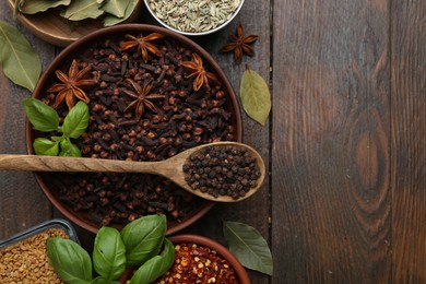 Photo of Different aromatic spices on wooden table, flat lay. Space for text