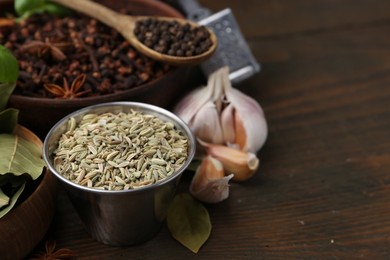Photo of Different aromatic spices on wooden table, closeup. Space for text