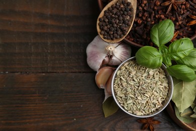 Photo of Different aromatic spices on wooden table, flat lay. Space for text
