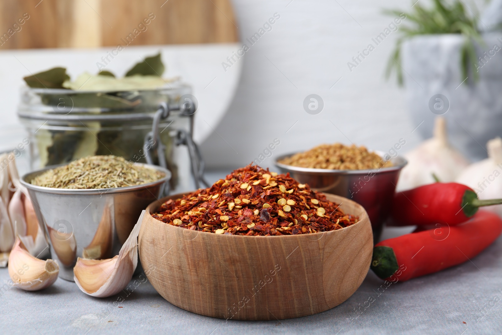 Different aromatic spices on grey table against light background, closeup Photo of Different aromatic spices on grey table against light background, closeup