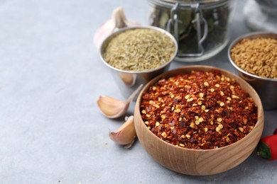 Photo of Different aromatic spices on grey table, closeup. Space for text