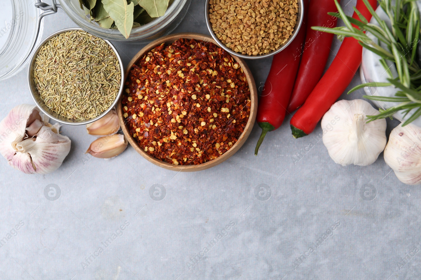 Different aromatic spices on grey table, flat lay. Space for text Photo of Different aromatic spices on grey table, flat lay. Space for text