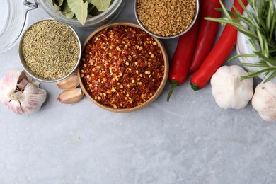 Photo of Different aromatic spices on grey table, flat lay. Space for text