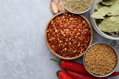 Photo of Different aromatic spices on grey table, flat lay. Space for text