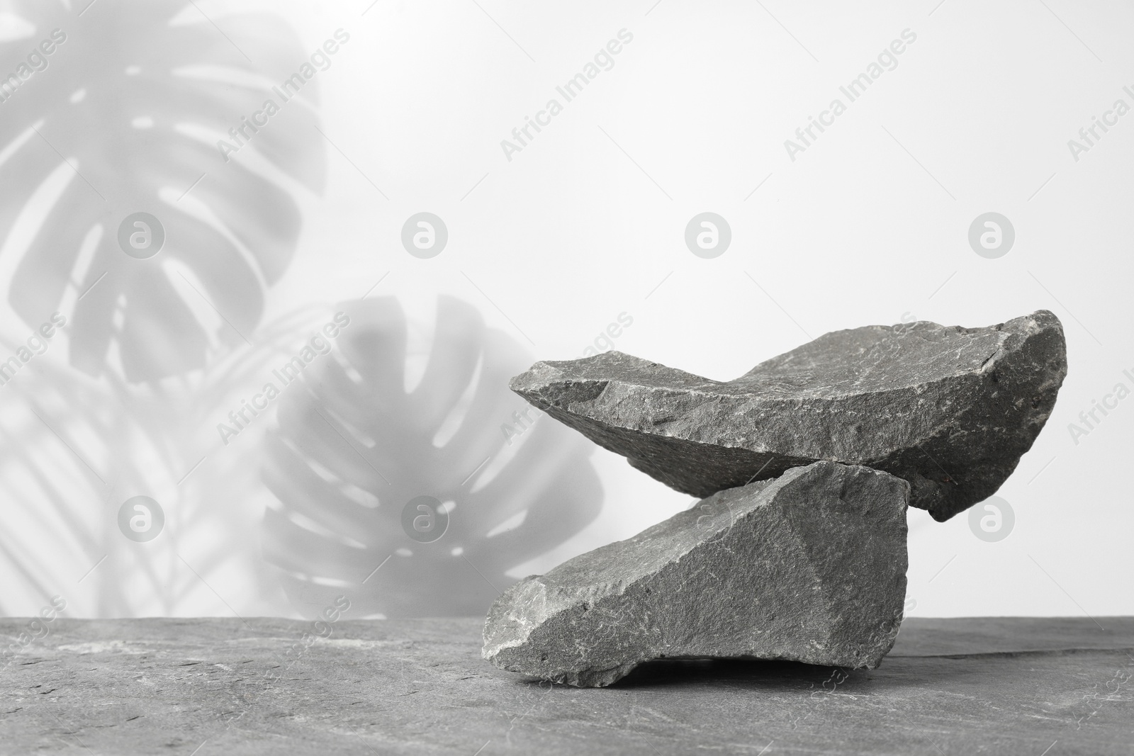 Podium for product presentation made of stones against white background with shadow of leaves. Space for design Image of Podium for product presentation made of stones against white background with shadow of leaves. Space for design