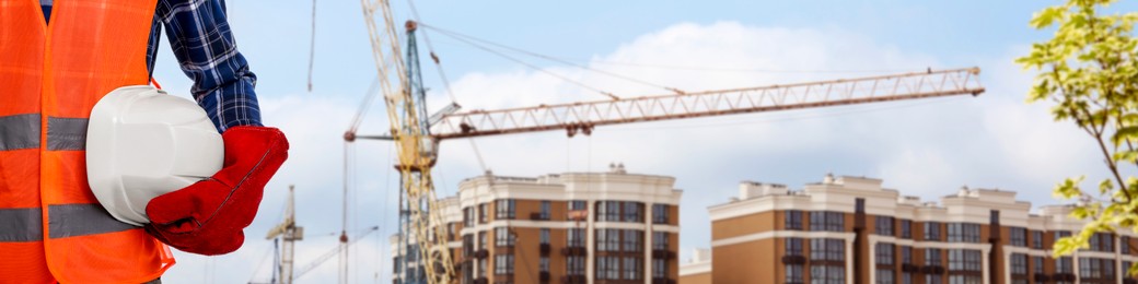 Image of Builder in safety equipment at construction site, closeup. Banner design