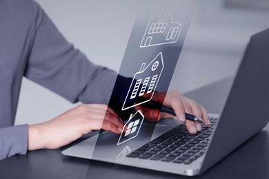 Image of Real estate agent working on laptop at table, closeup. Virtual screen with buildings icons. Search for housing