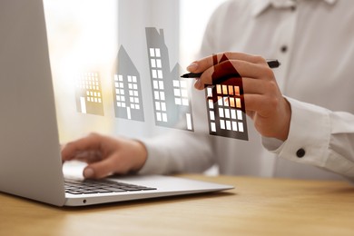 Image of Real estate agent touching house icon on virtual screen while working on laptop at table, closeup. Search for housing