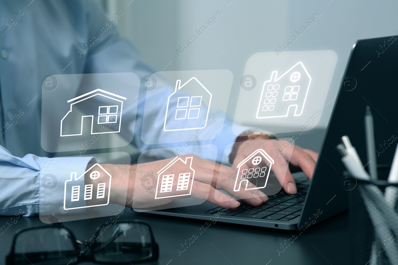 Image of Real estate agent looking for housing via laptop at table, closeup. Illustrations of different buildings over device