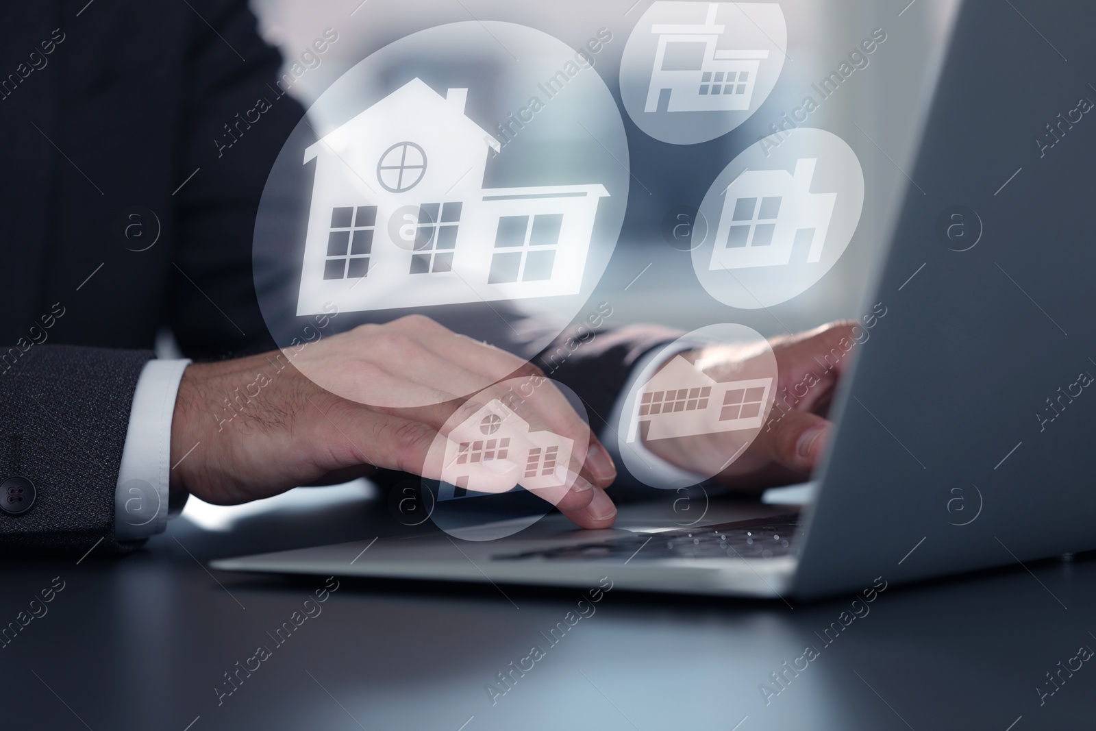 Real estate agent looking for housing via laptop at table, closeup. Illustrations of different buildings over device Image of Real estate agent looking for housing via laptop at table, closeup. Illustrations of different buildings over device
