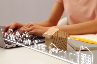 Image of Real estate agent looking for housing via laptop at white table, closeup. Virtual screen with different buildings icons