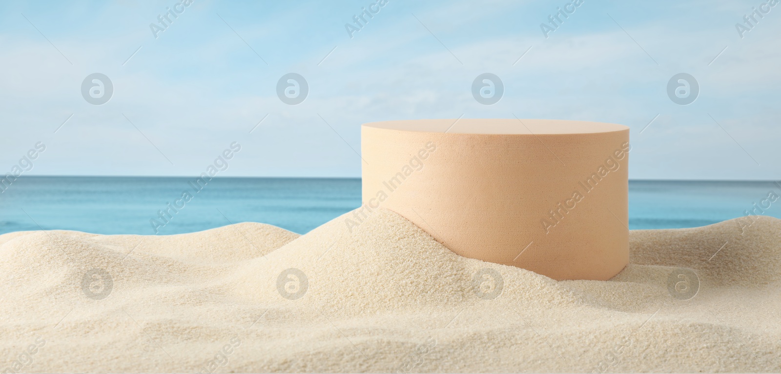 Image of Podium for product promotion on sand near blue sea, banner design. Stylish presentation
