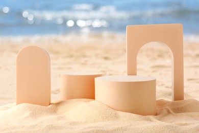 Image of Podium for product presentation. Figures on sand near blue sea. Stylish promotion poster
