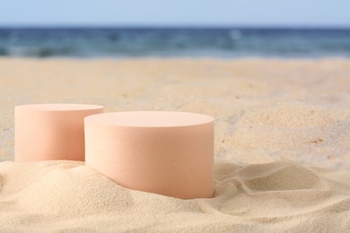 Image of Podium for product presentation. Figures on sand near blue sea. Stylish promotion poster