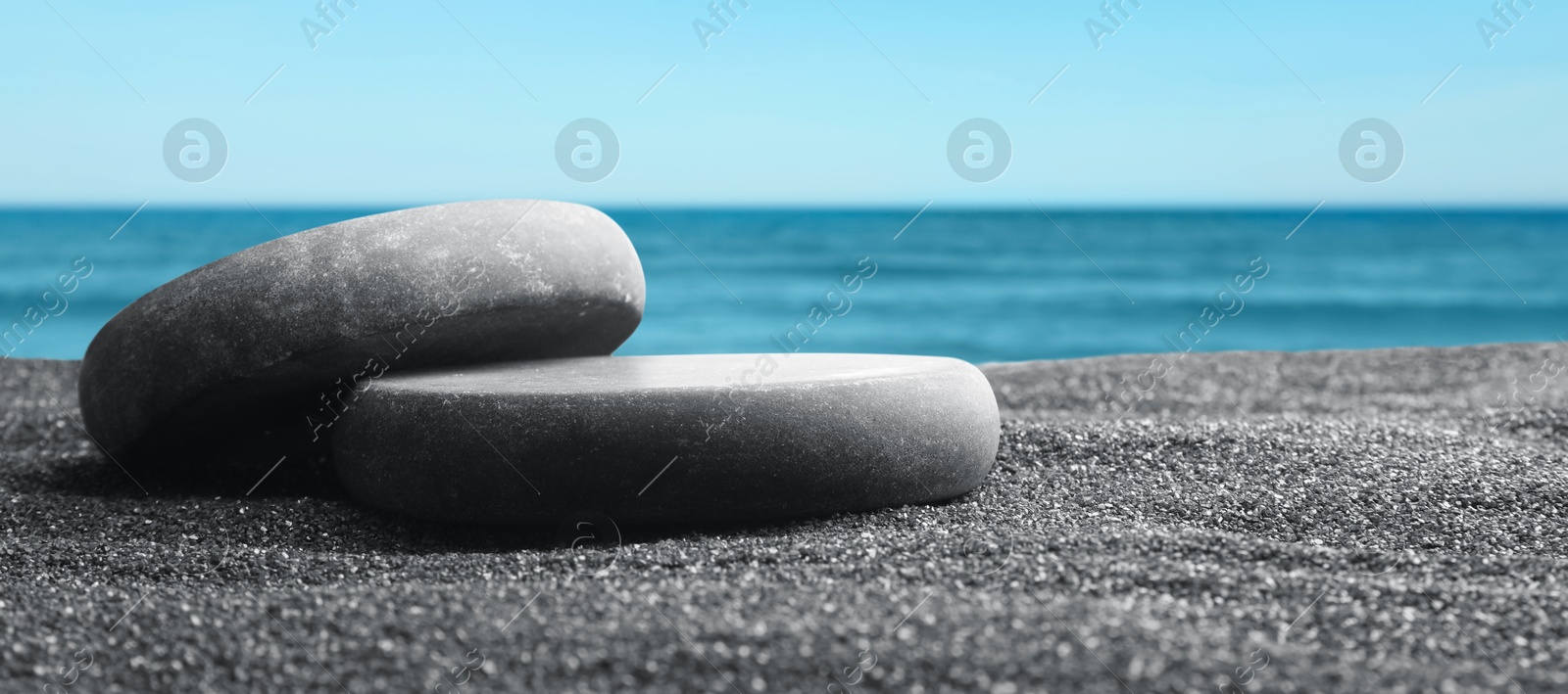 Image of Podium for product presentation. Stones on sand near sea, banner design. Stylish promotion poster