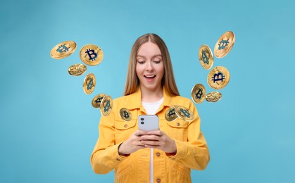 Image of Cryptocurrency. Happy woman using smartphone on light blue background. Bitcoins flying out of device