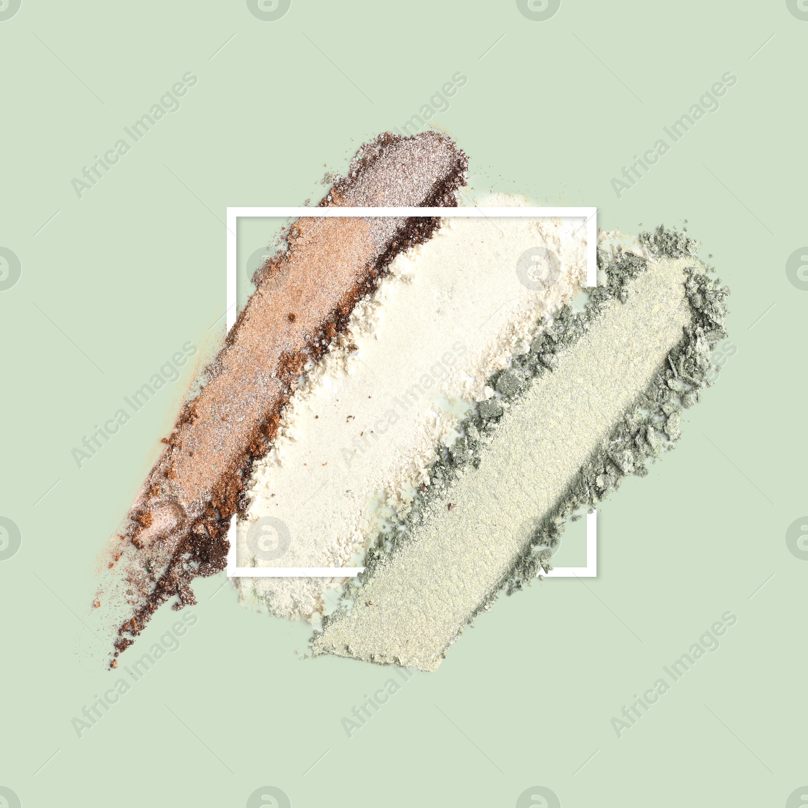 Image of Crushed eye shadows and frame on pastel green background. Color palette of makeup product