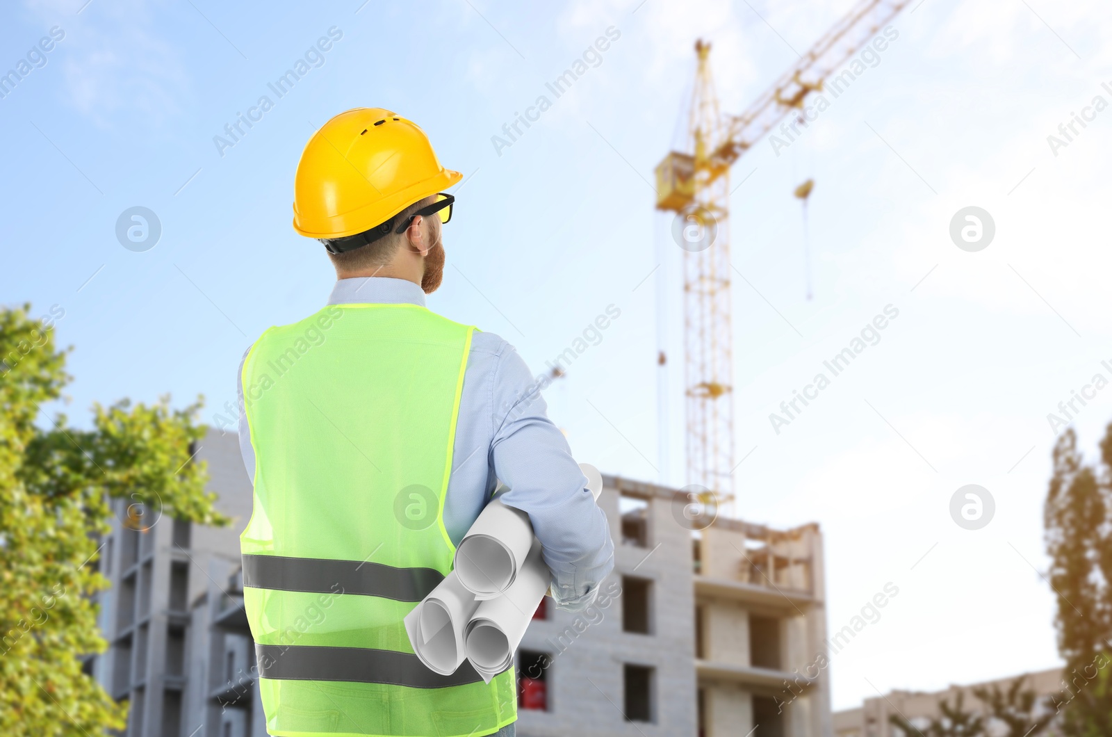 Engineer in safety equipment looking at construction site Image of Engineer in safety equipment looking at construction site