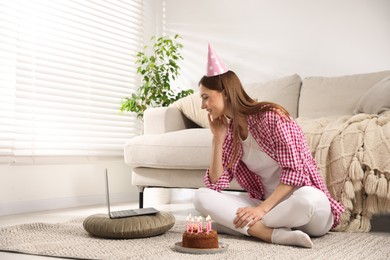 Photo of Birthday celebration. Happy woman with tasty cake having video call via laptop at home