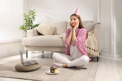 Photo of Birthday celebration. Happy woman with piece of cake having video call via laptop at home