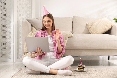 Photo of Birthday celebration. Happy woman having video call via laptop at home