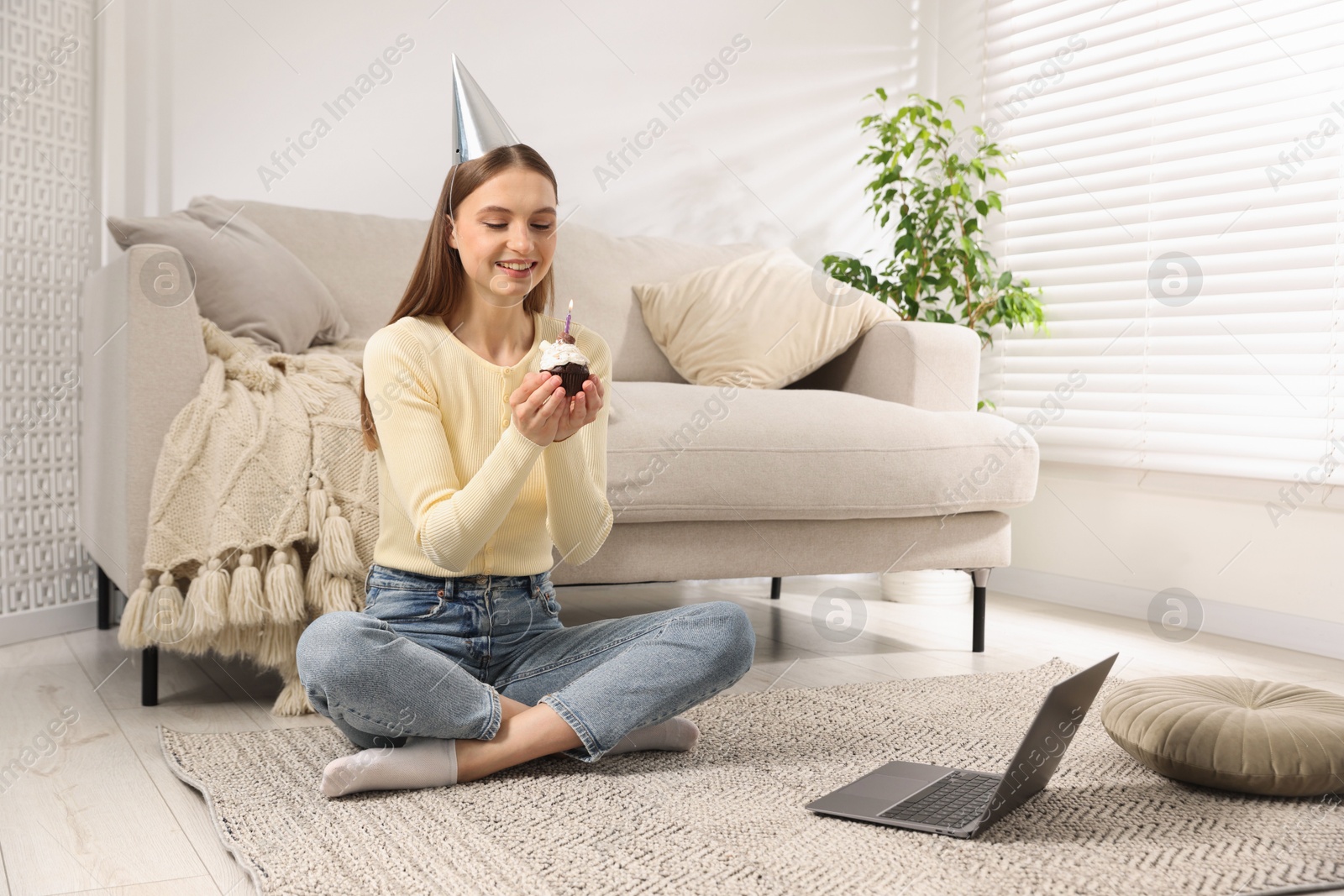 Birthday celebration. Happy woman with cupcake having video call via laptop at home Photo of Birthday celebration. Happy woman with cupcake having video call via laptop at home
