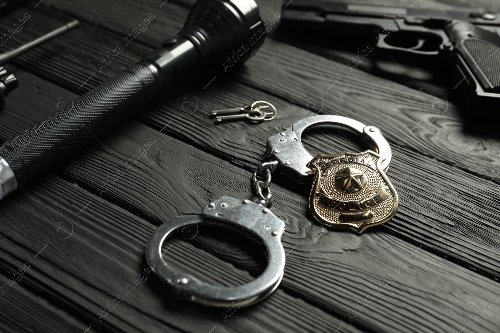 Different police equipment on black wooden table, closeup Photo of Different police equipment on black wooden table, closeup
