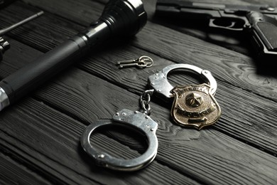 Photo of Different police equipment on black wooden table, closeup