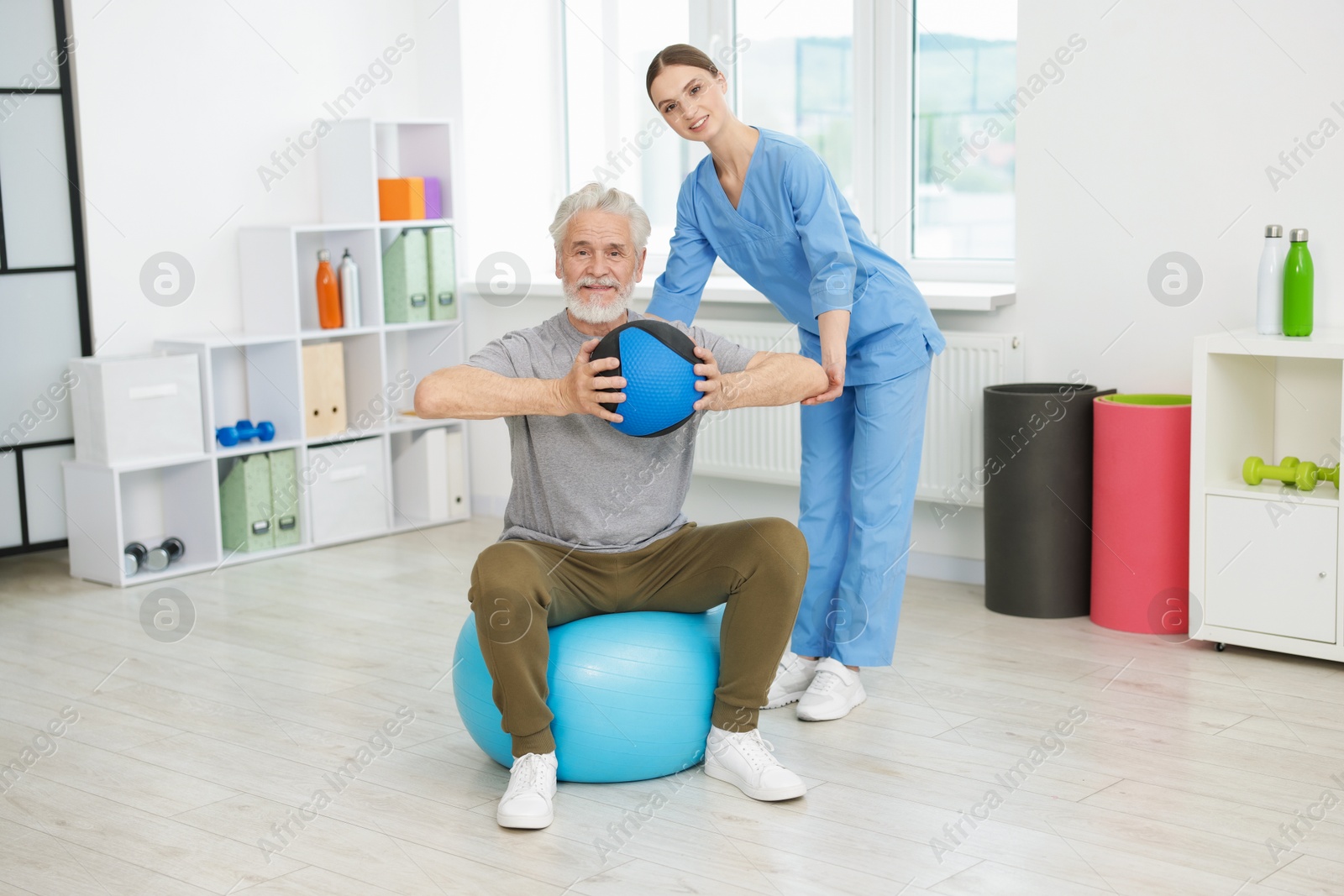 Doctor and patient exercising with medicine ball in clinic Photo of Doctor and patient exercising with medicine ball in clinic