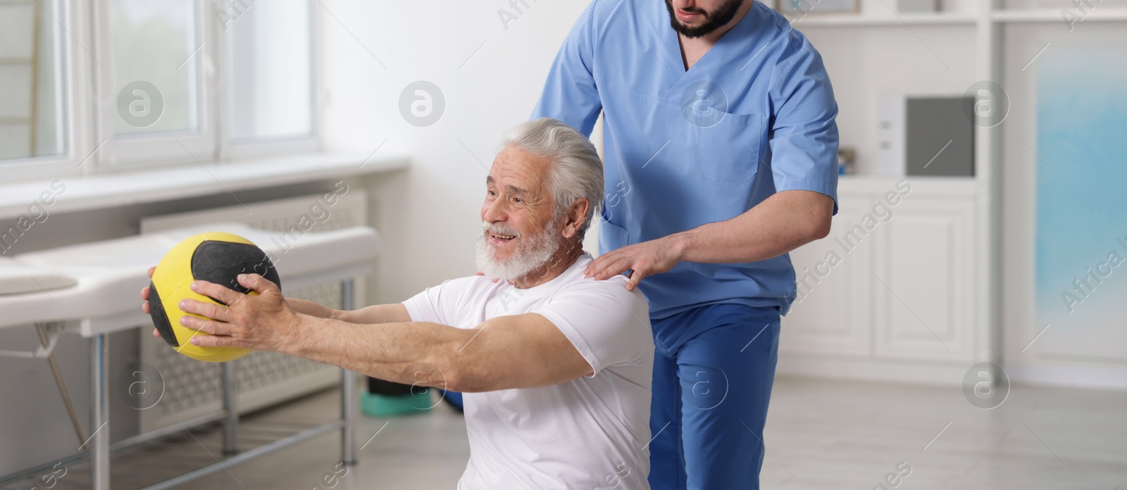 Doctor and patient exercising with medicine ball in clinic Photo of Doctor and patient exercising with medicine ball in clinic