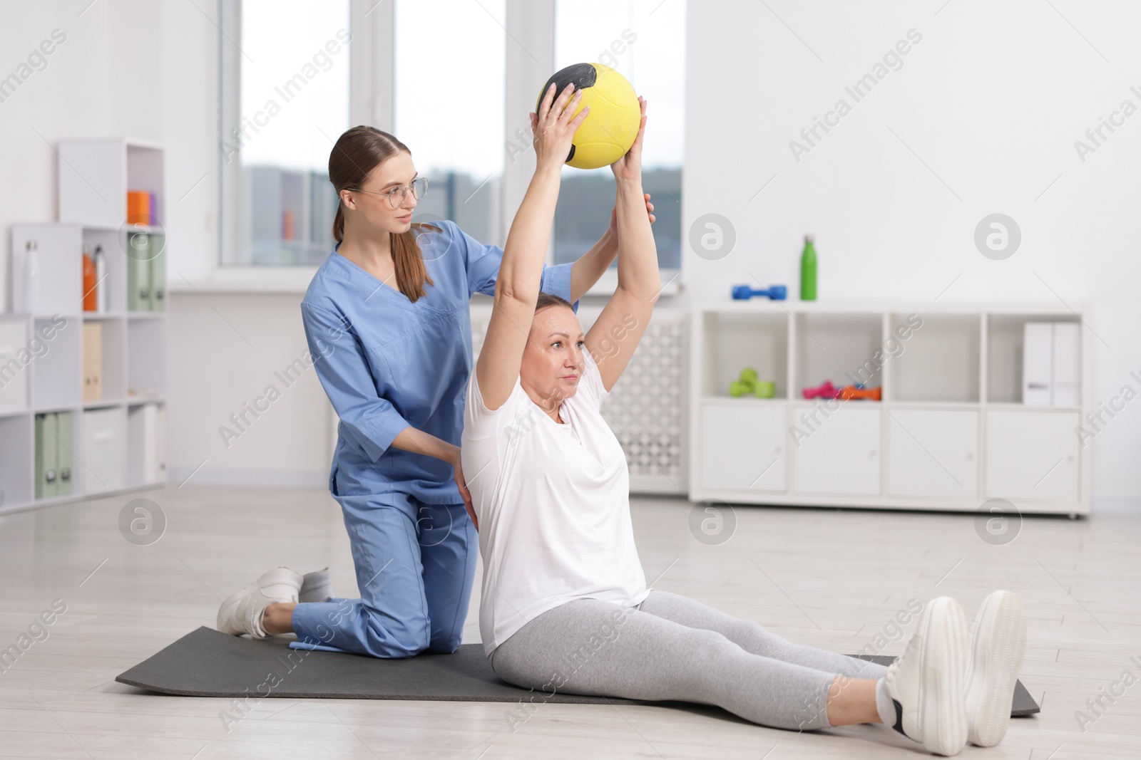 Doctor and patient exercising with medicine ball in clinic Photo of Doctor and patient exercising with medicine ball in clinic
