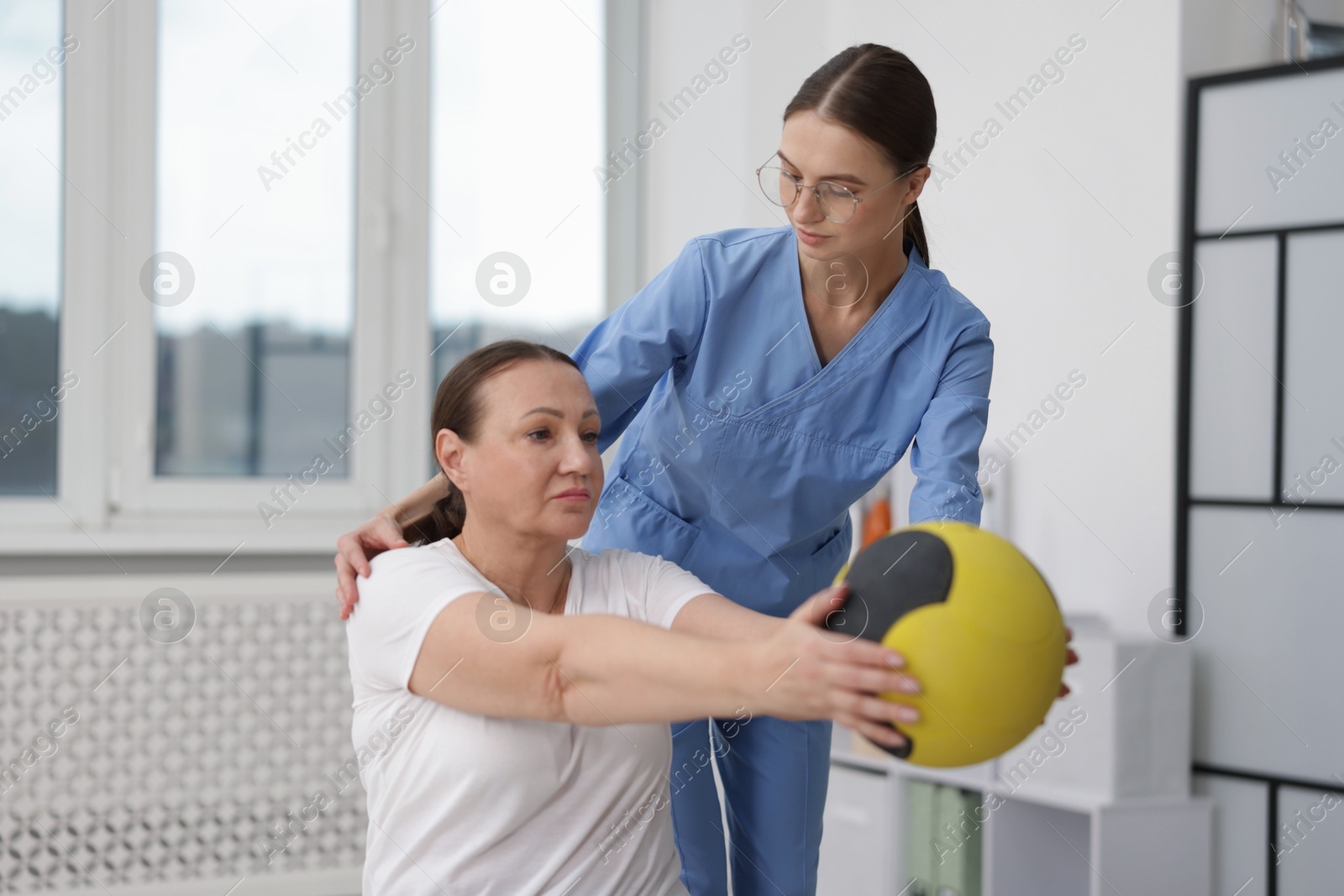 Doctor and patient exercising with medicine ball in clinic Photo of Doctor and patient exercising with medicine ball in clinic