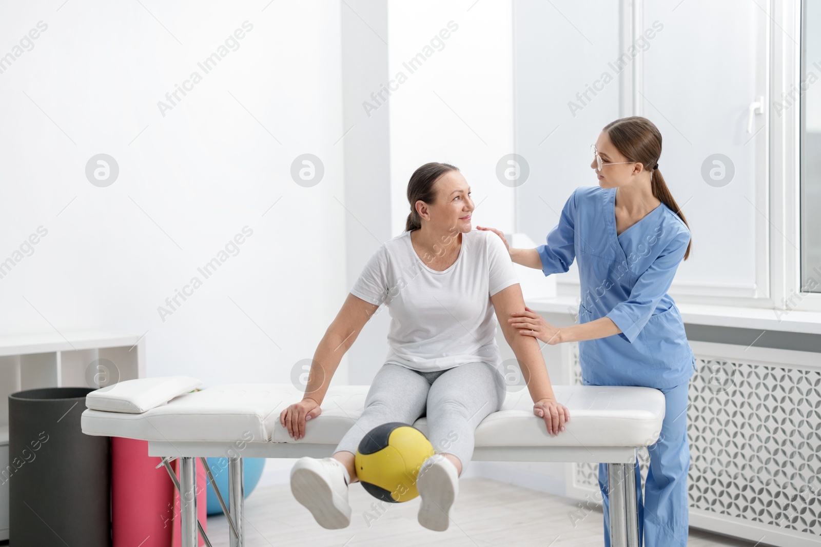 Doctor and patient exercising with medicine ball in clinic Photo of Doctor and patient exercising with medicine ball in clinic