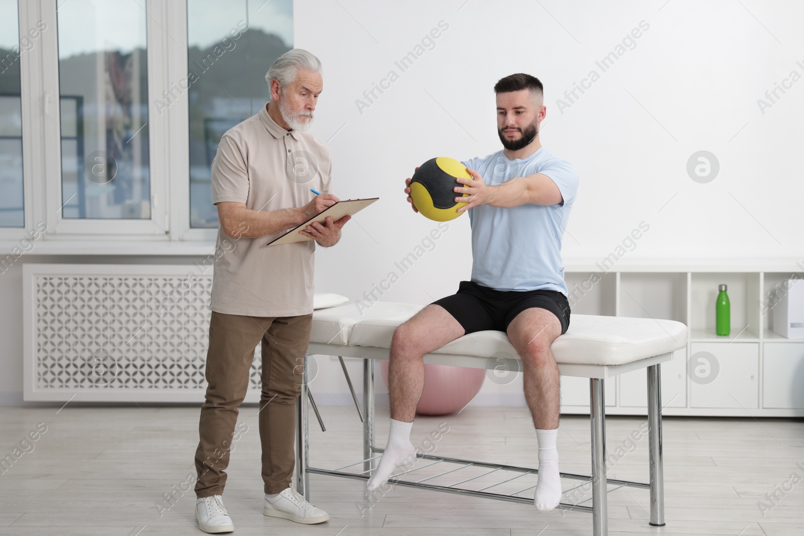 Doctor and patient exercising with medicine ball in clinic Photo of Doctor and patient exercising with medicine ball in clinic