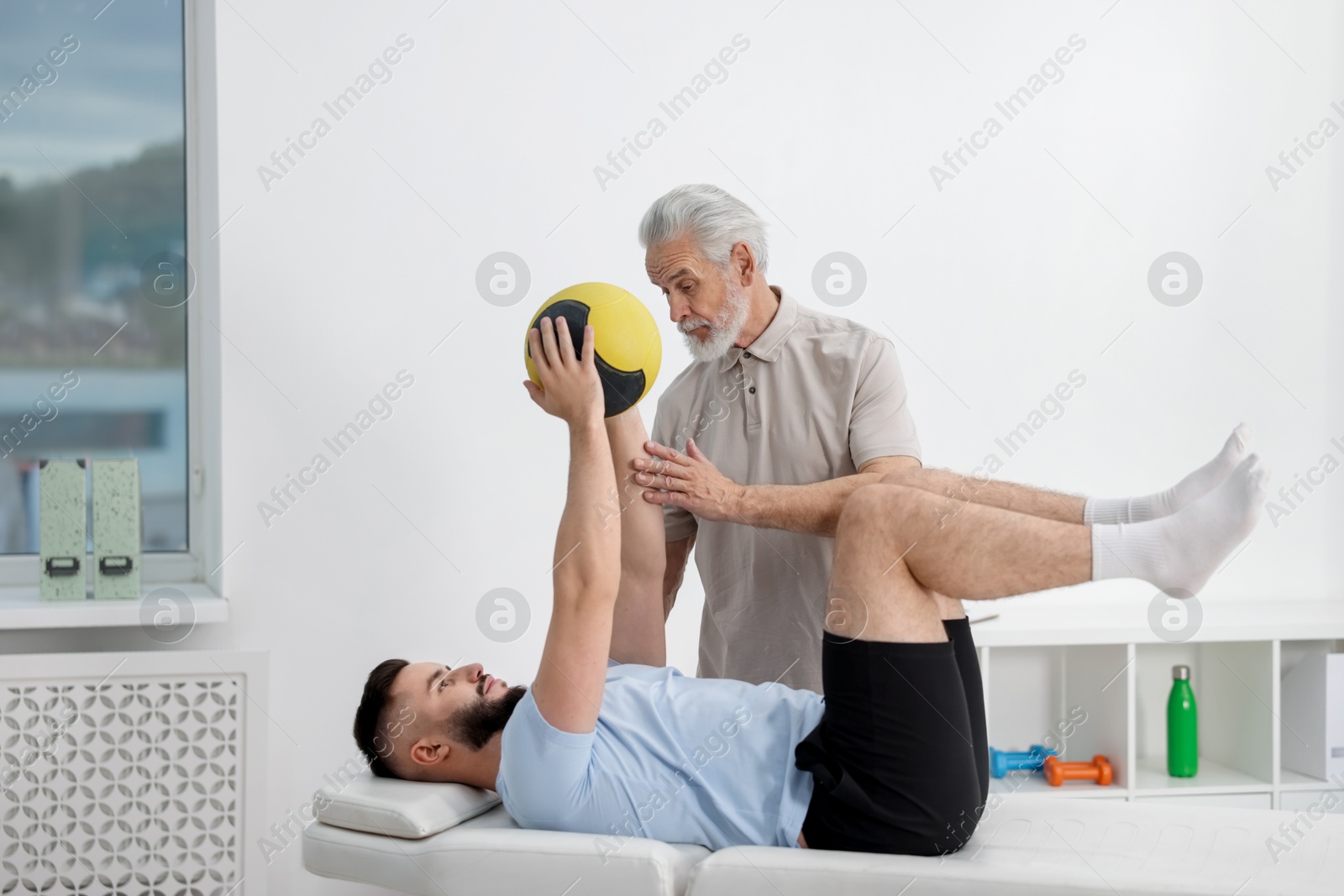 Doctor and patient exercising with medicine ball in clinic Photo of Doctor and patient exercising with medicine ball in clinic
