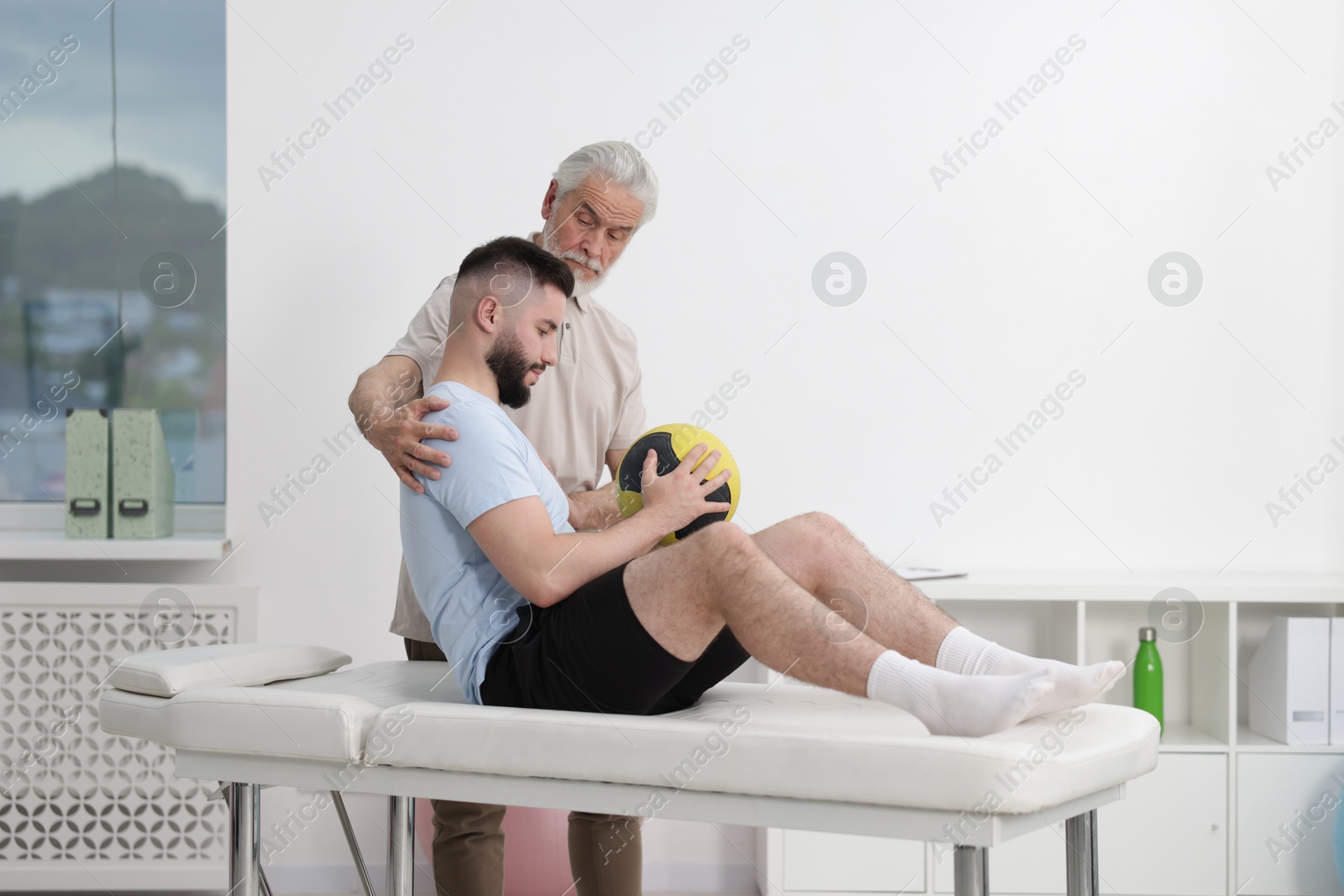 Doctor and patient exercising with medicine ball in clinic Photo of Doctor and patient exercising with medicine ball in clinic