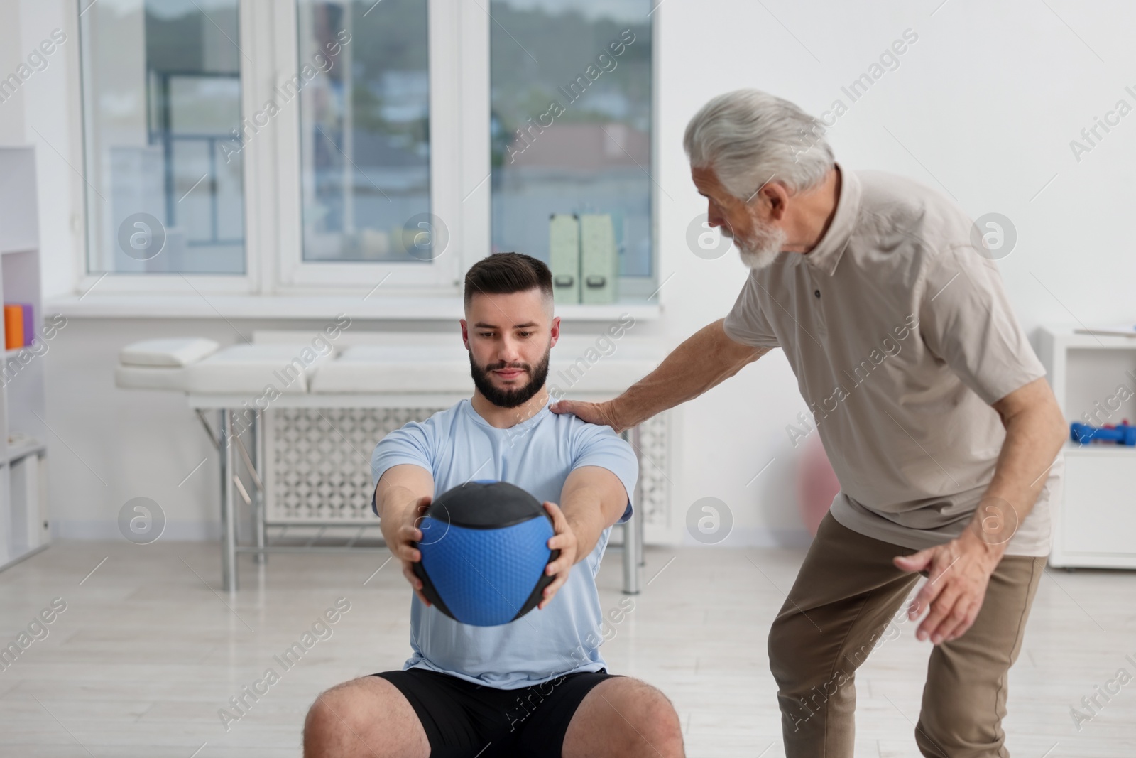 Doctor and patient exercising with medicine ball in clinic Photo of Doctor and patient exercising with medicine ball in clinic