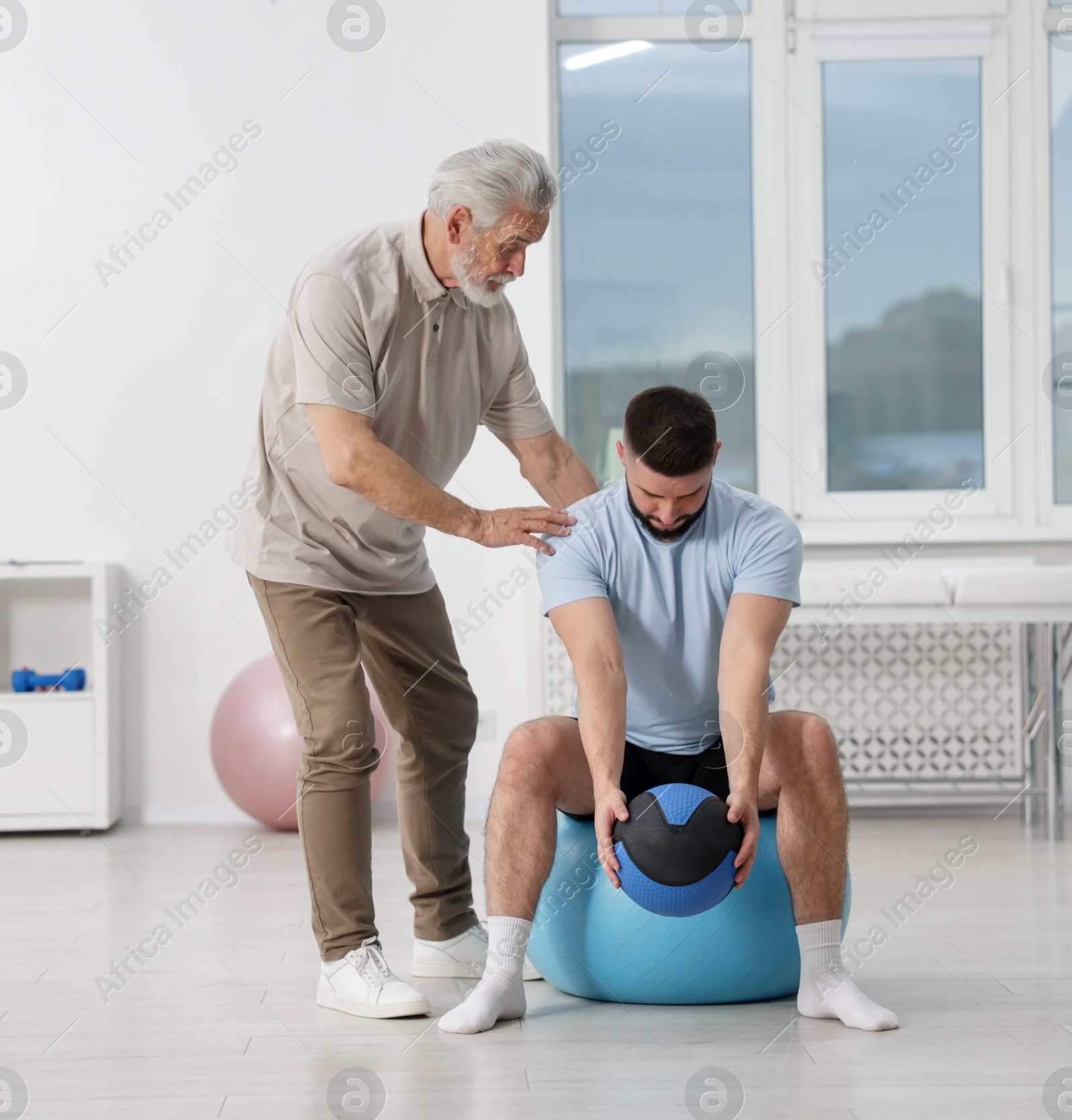 Doctor and patient exercising with medicine ball in clinic Photo of Doctor and patient exercising with medicine ball in clinic