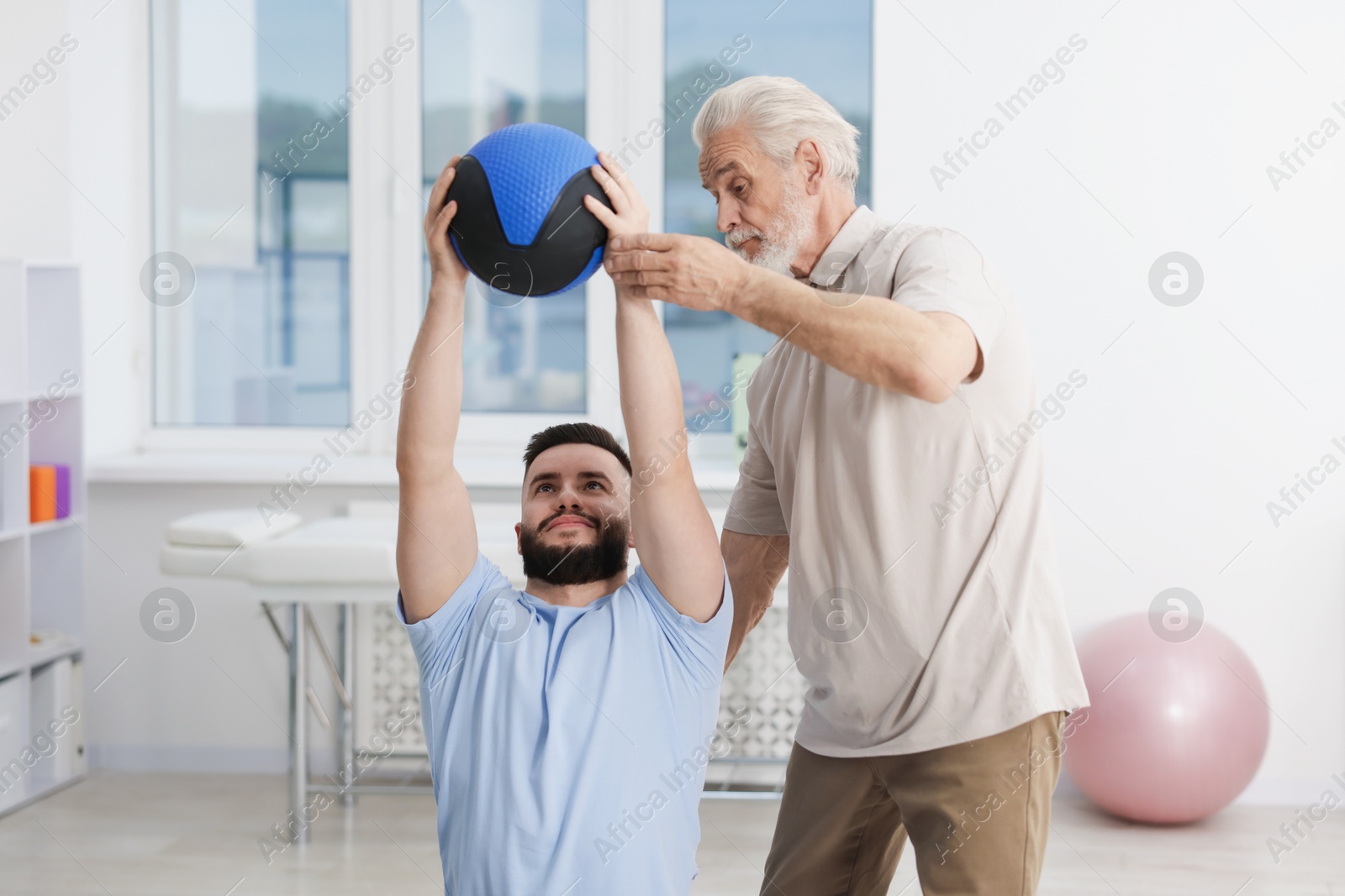 Doctor and patient exercising with medicine ball in clinic Photo of Doctor and patient exercising with medicine ball in clinic