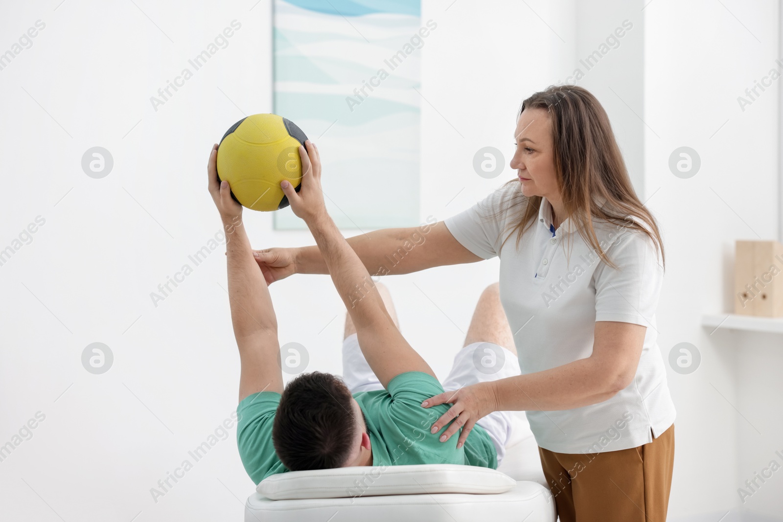 Doctor and patient exercising with medicine ball in clinic Photo of Doctor and patient exercising with medicine ball in clinic