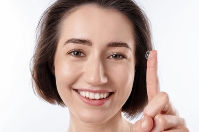 Photo of Woman with contact lens on white background, closeup