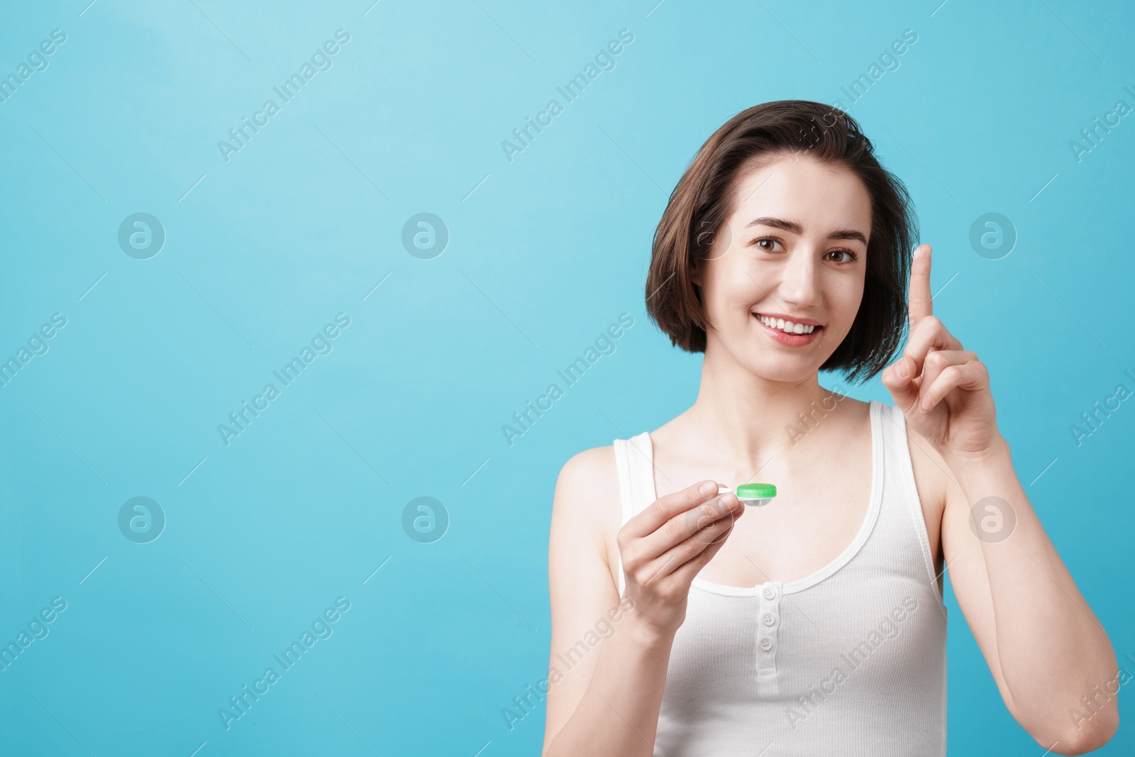 Woman with contact lens and case on light blue background. Space for text Photo of Woman with contact lens and case on light blue background. Space for text