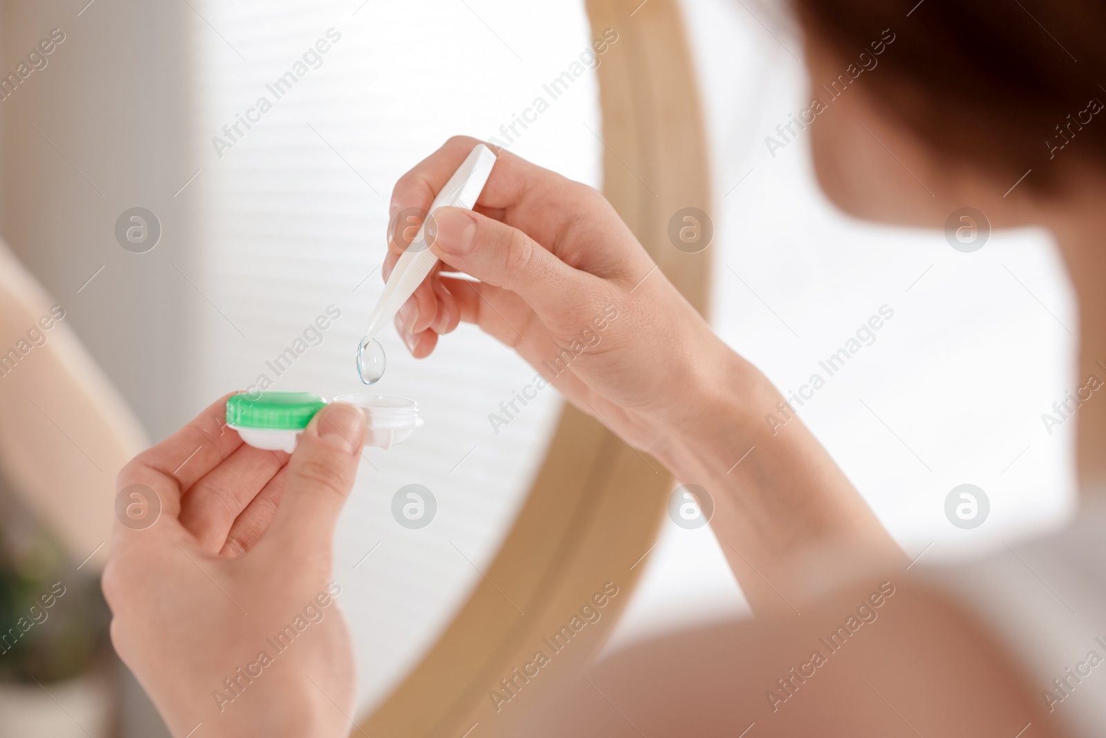 Woman taking contact lens out of case indoors, closeup Photo of Woman taking contact lens out of case indoors, closeup